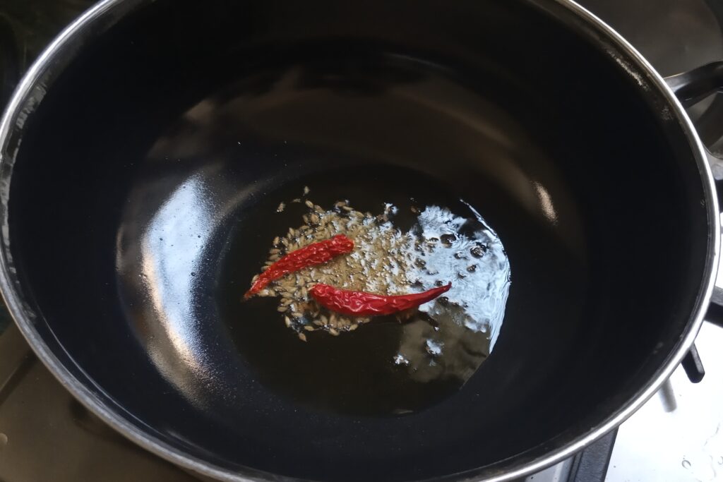 Tempering cumin seeds & chilies in a oil