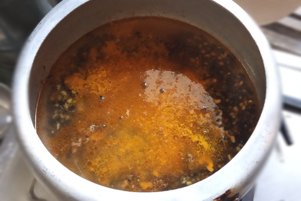 Adding spices and water to black dal