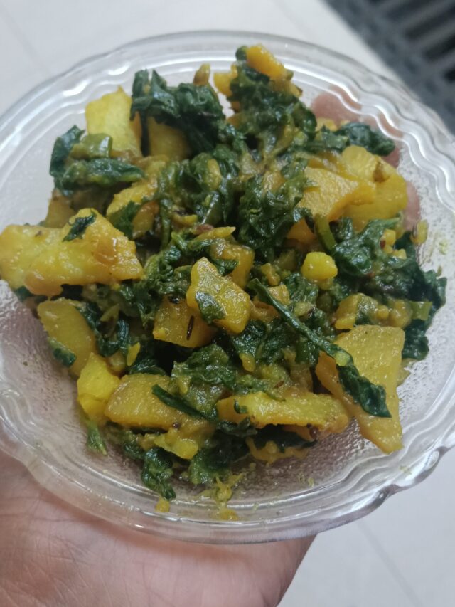 Homestyle dry palak aloo sabzi in a glass bowl