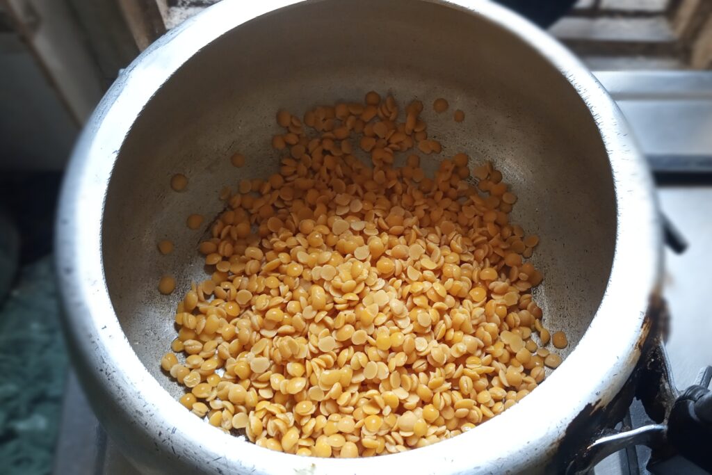 Add soaked arhar dal in a pressure cooker