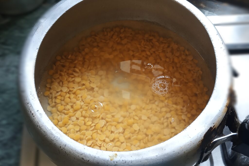 Pour water in the arhar dal