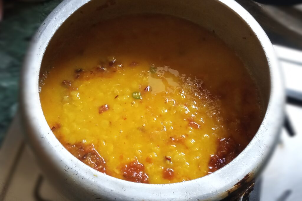 Pouring the cooked dal in tomatoes