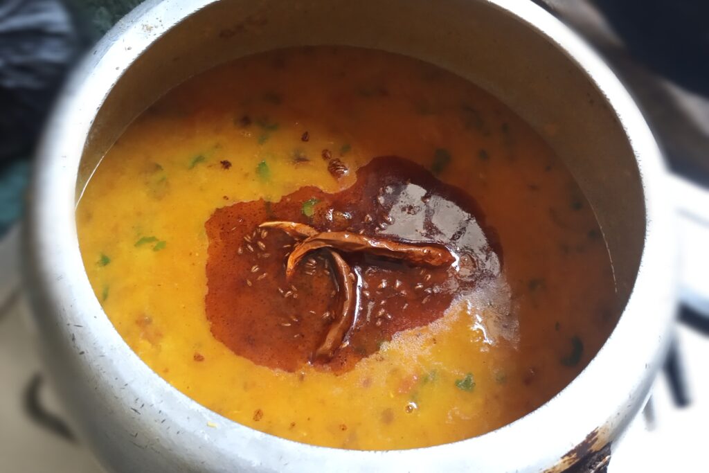 Adding tadka on the cooked toor dal