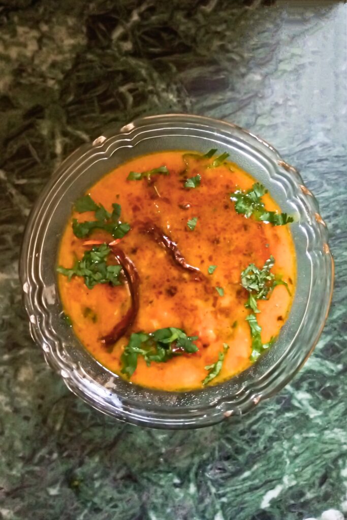 Hot dal tadka recipe topped with tempering and herbs