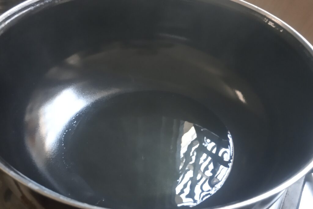 heating oil in a kadai for potato peas curry