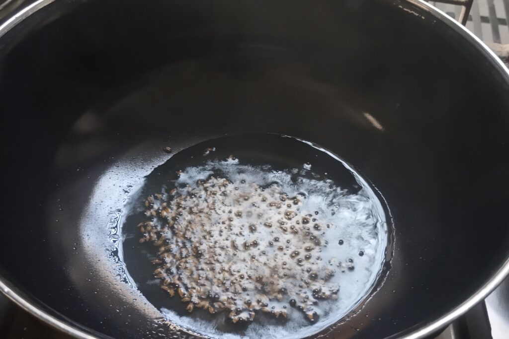 tempering cumin seeds in the heated oil