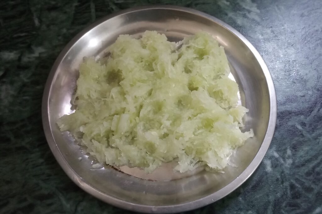 squeezing grated cucumber for raita