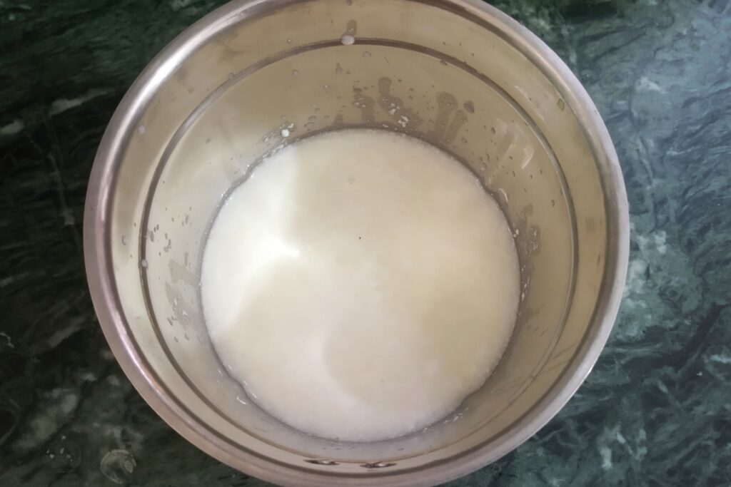adding curd to the blender for masala chaas