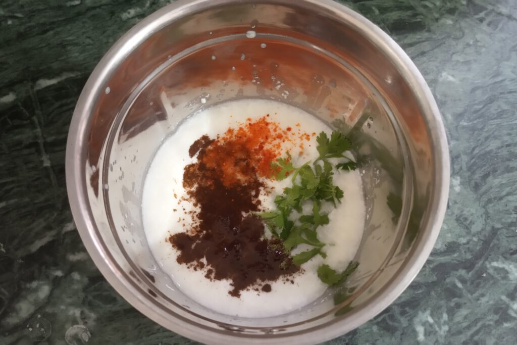 adding spices and coriander leaves to blend