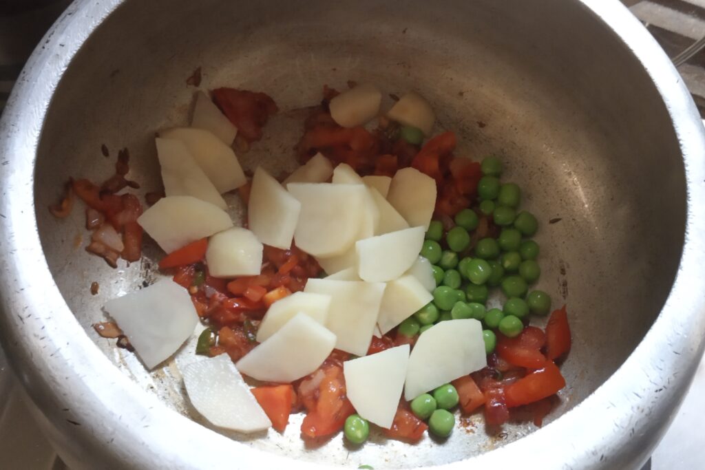 adding chopped vegetables to tomatoes