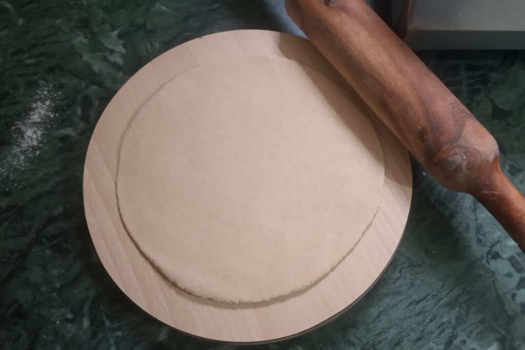 rolling roti into circle with rolling pin