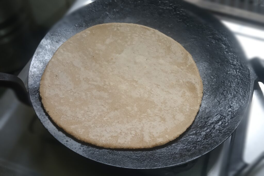 cooking roti the heated tawa