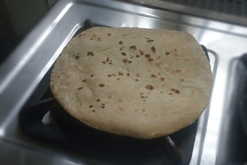 cooking roti on the flame