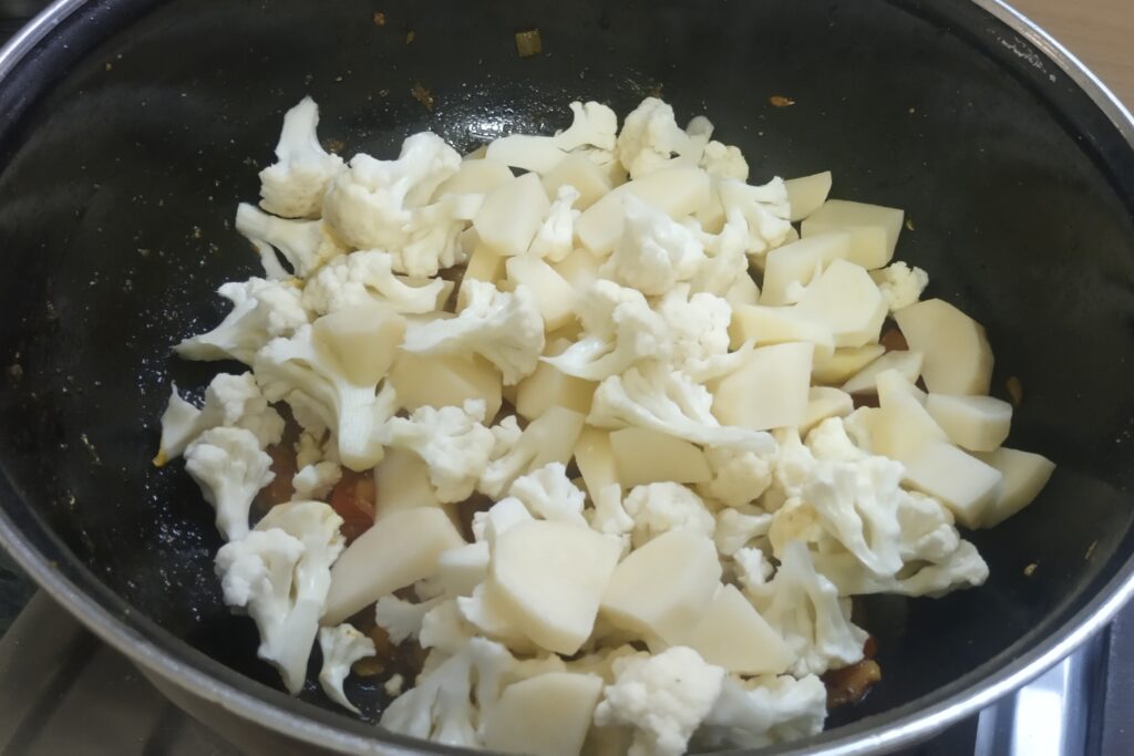 adding chopped potatoes and cauliflower