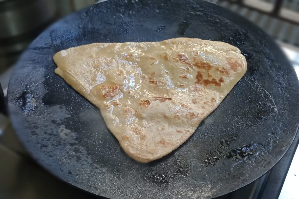 roasting the triangle paratha