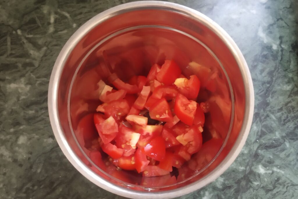 adding tomato juice to a blender