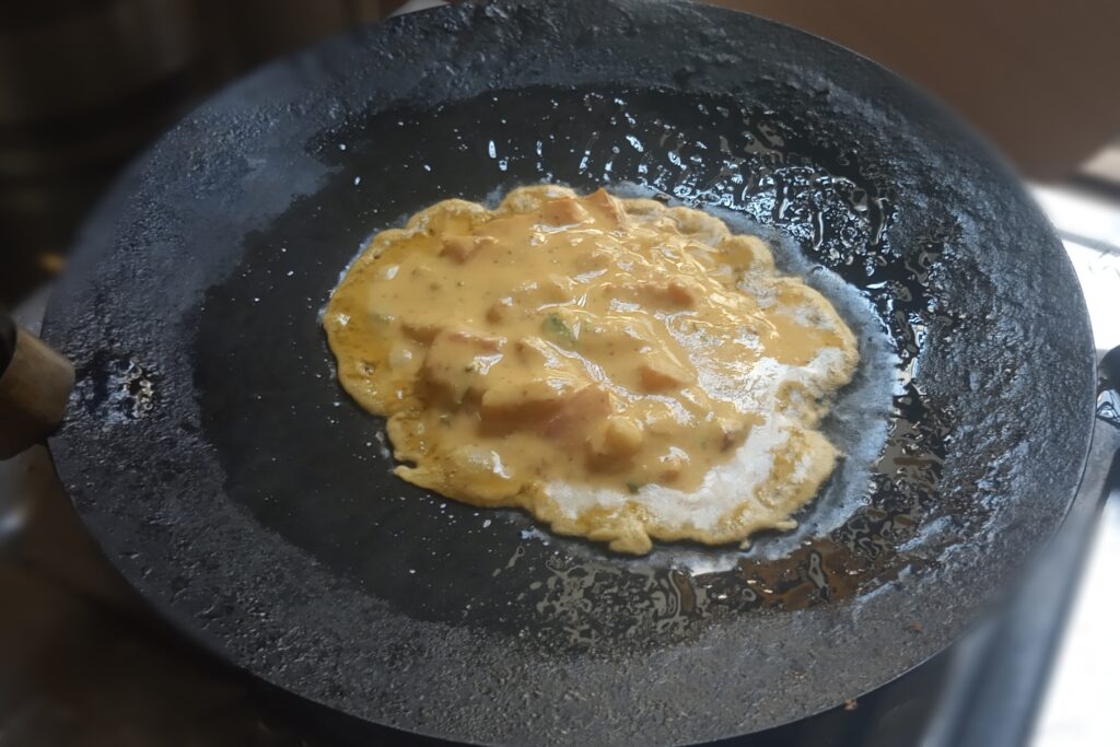pouring batter in the heated tawa