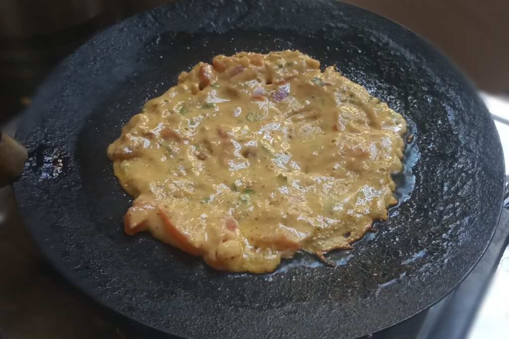 spreading batter over the tawa