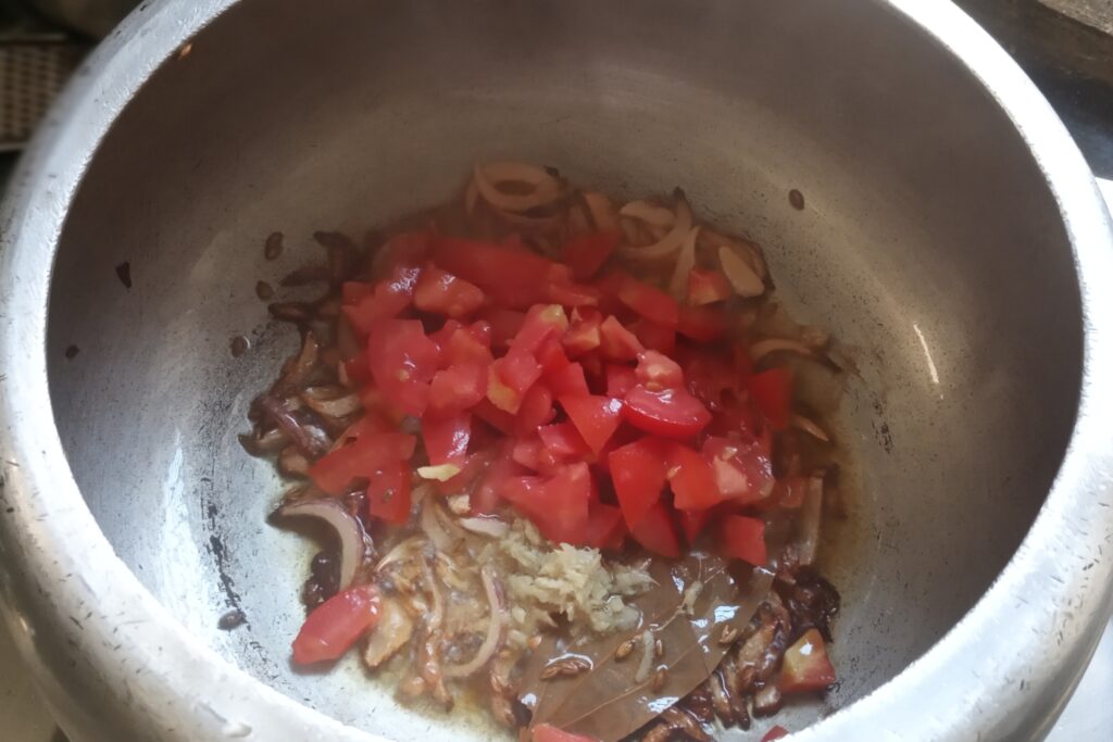 adding tomato and ginger garlic to saute