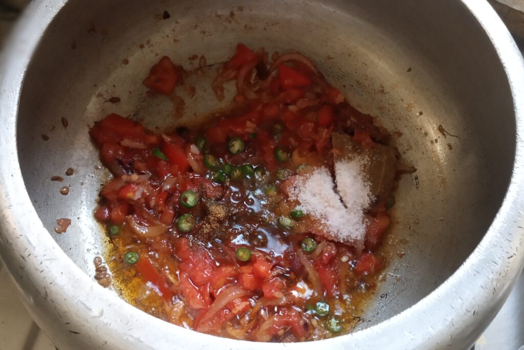 season spices and green chilies in mushy tomato
