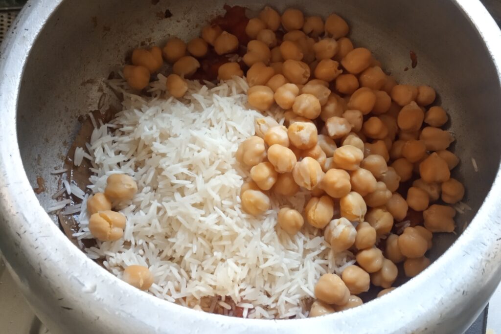 adding rice and chickpeas to masala