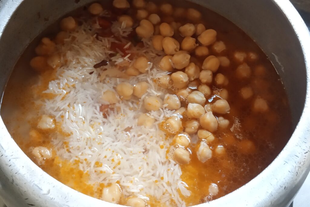 adds water to make chickpea pulao