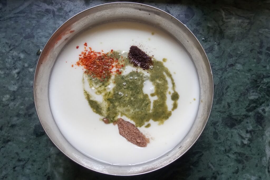 adding spices and mint paste to the curd