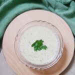 top shot of mint raita recipe with a garnish of mint leaves