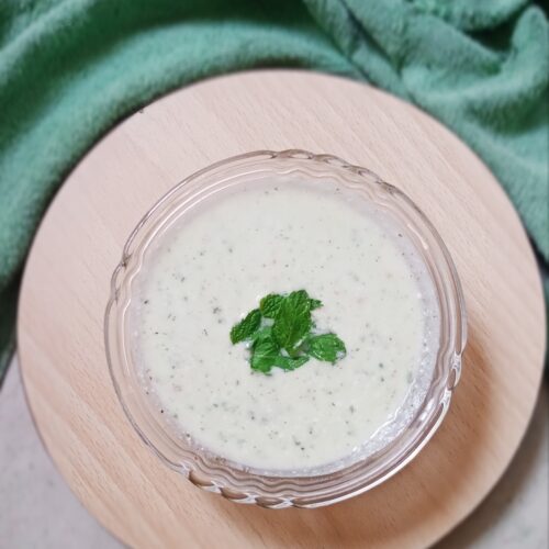 top shot of mint raita recipe with a garnish of mint leaves