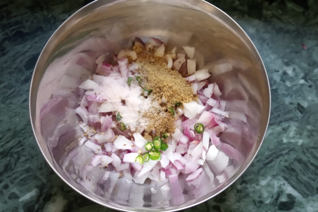 adding spices and green chili in chopped onions