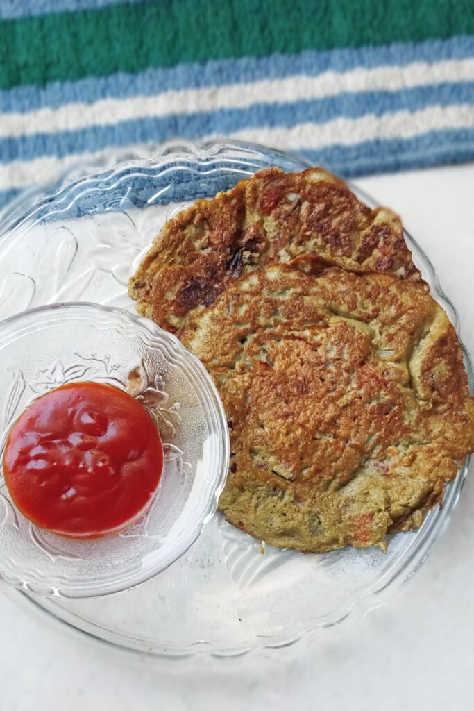 top shot of green moong dal chilla and tomato ketchup