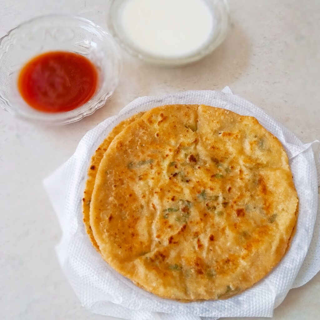 aloo paratha served with curd and ketchup