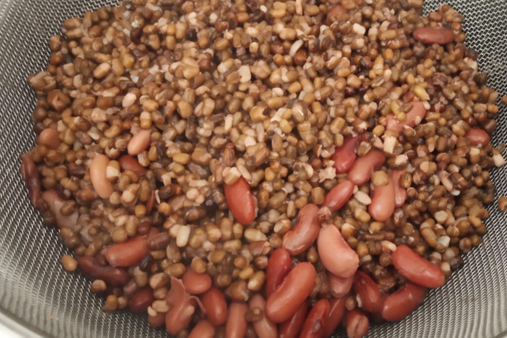 boiled urad dal and rajma in a strainer