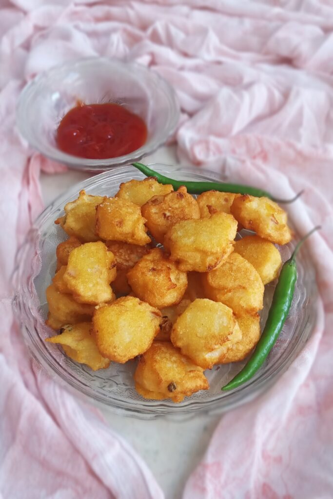 close up shot of suji pakora with green chili and sauce