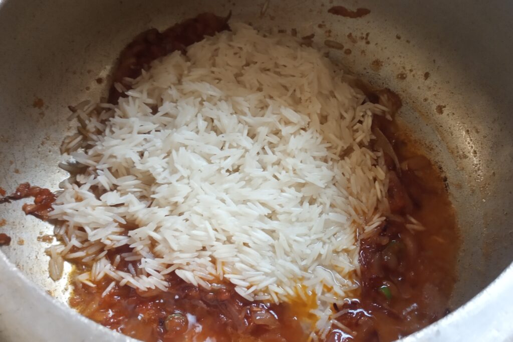 adding soaked rice to the masala