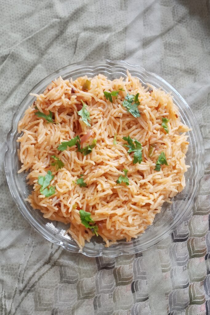 top shot of onion pulao recipe garnished with coriander leaves