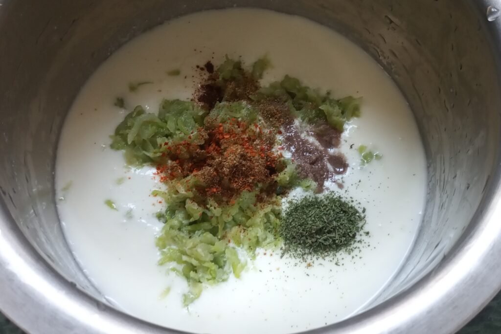adding squeezed lauki and spices in a curd