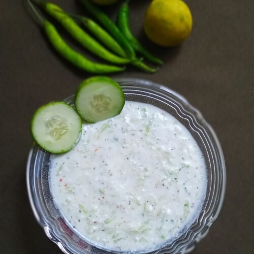 lauki raita recipe with sliced cucumber in a bowl