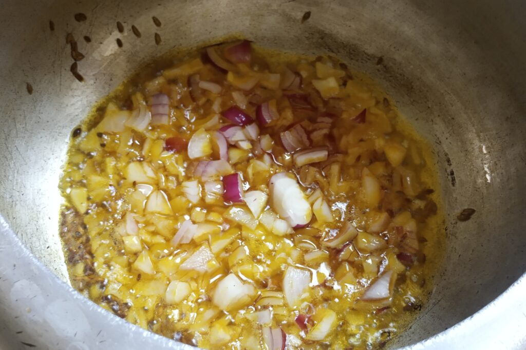 adding chopped onion in cumin seeds