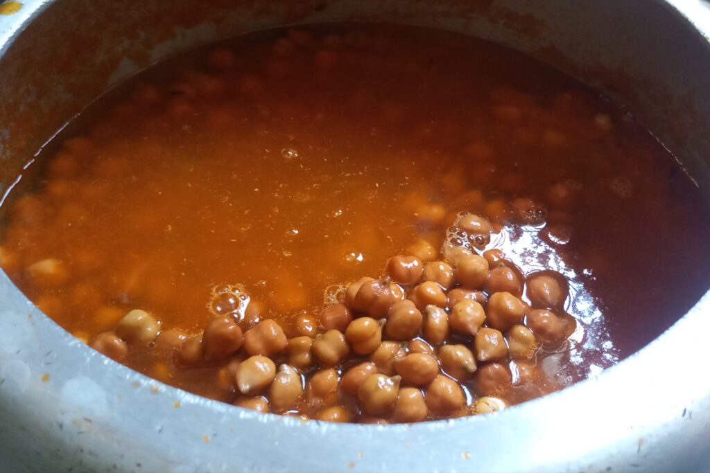 pouring water to cook chana curry