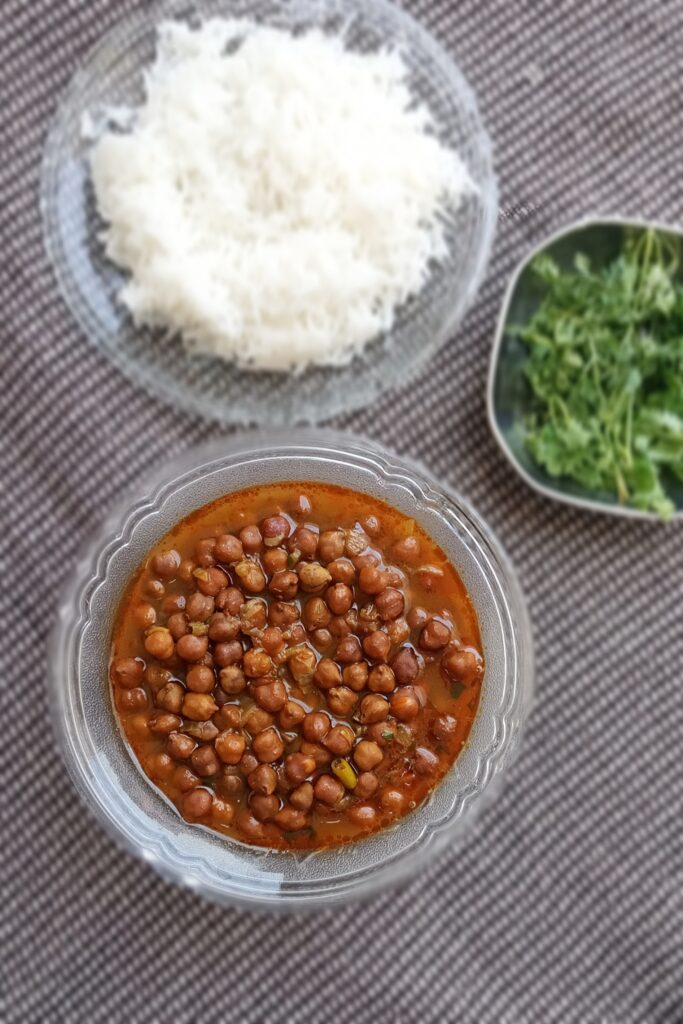 top shot of kala chana curry rice and herbs