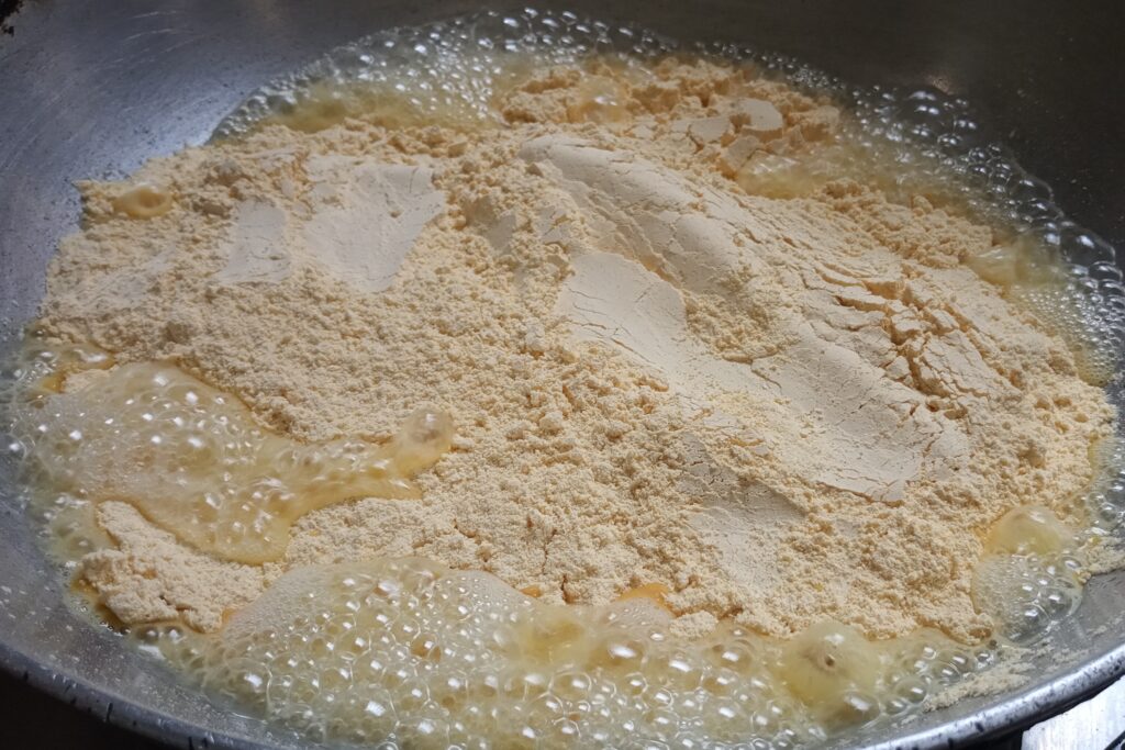 adding gram flour in the heated ghee