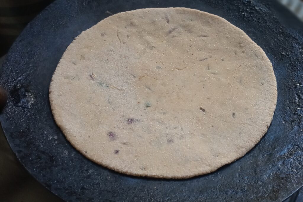 placed the rolled stuffed circle on hot tawa