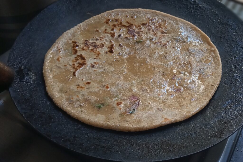 cooking sattu paratha on hot tawa