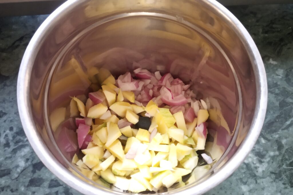 adding chopped onions and mangoes to a jar