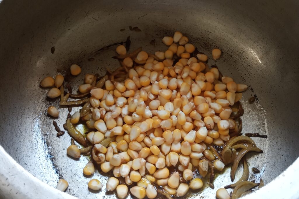 adding sweet corn in onion masala
