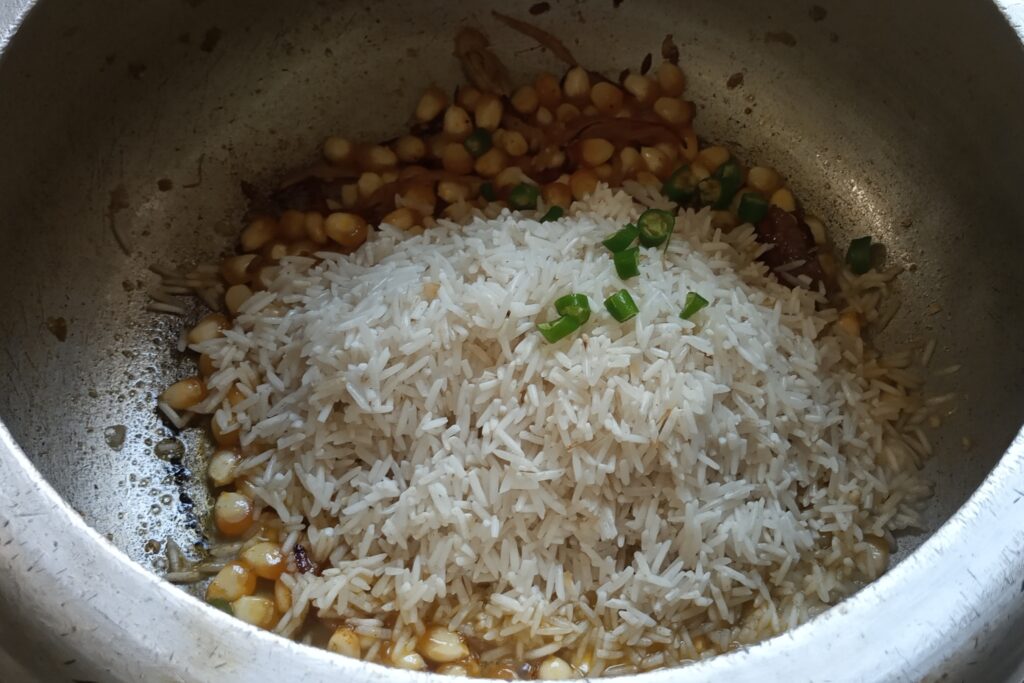 adding soaked rice and chilies