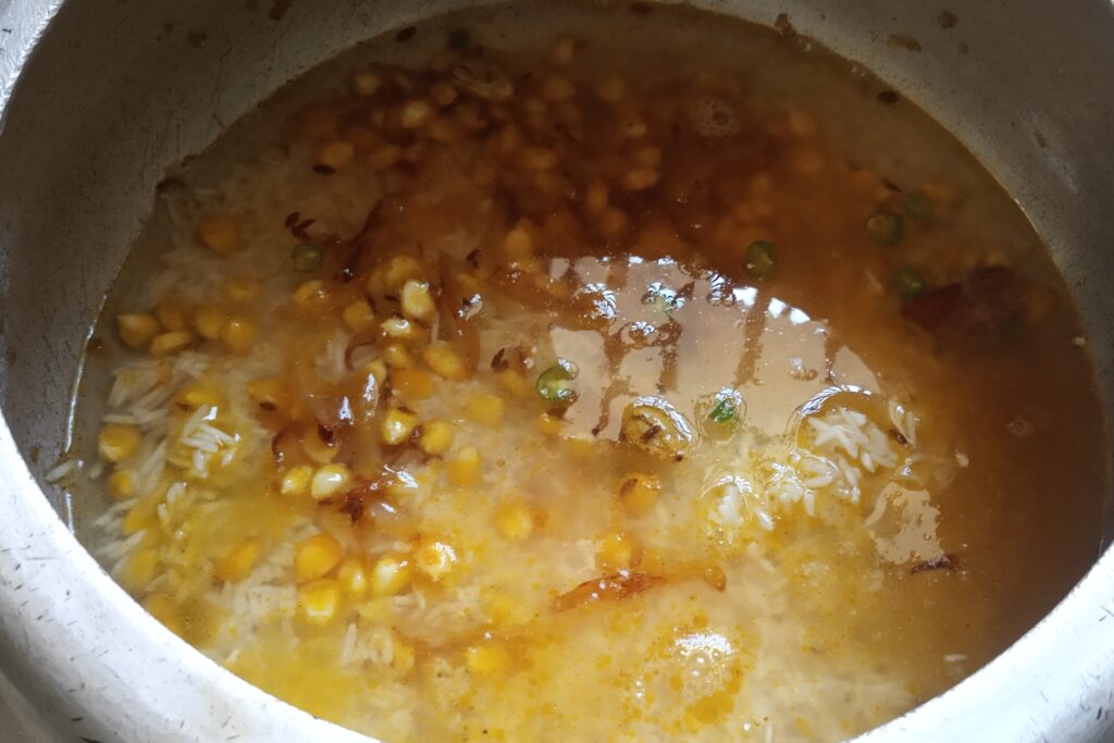 adding water to the rice and corn
