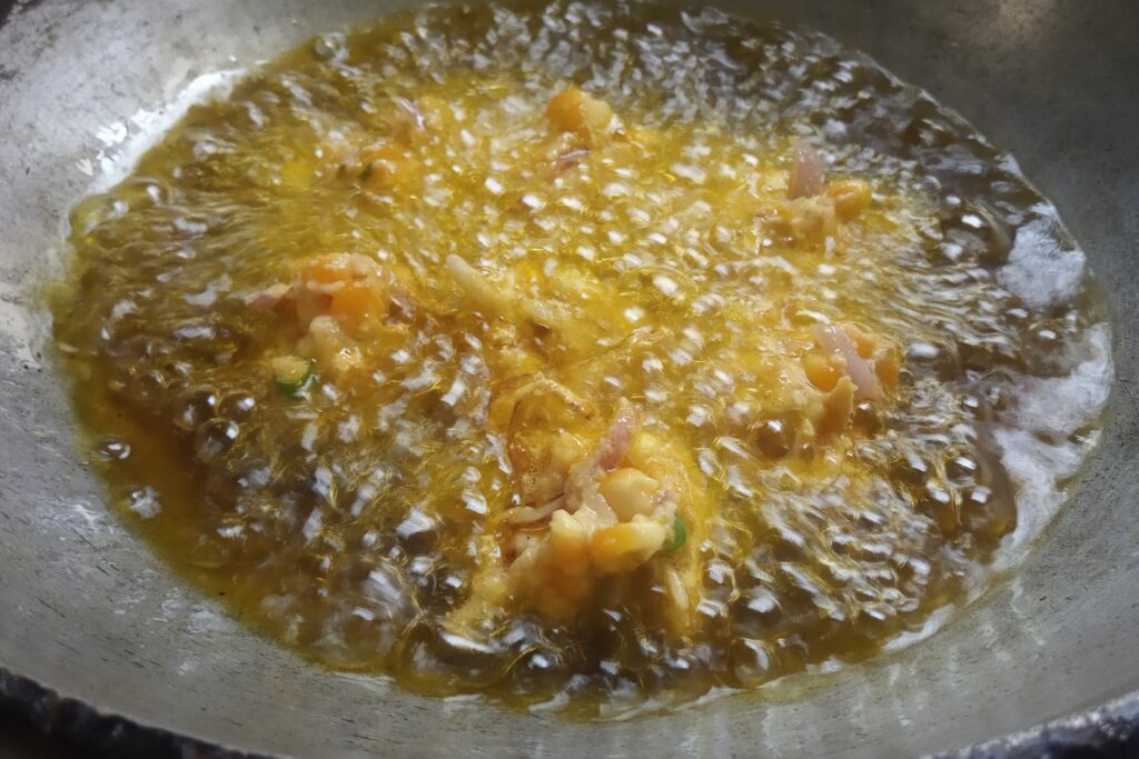 frying corn pakoras in the hot oil
