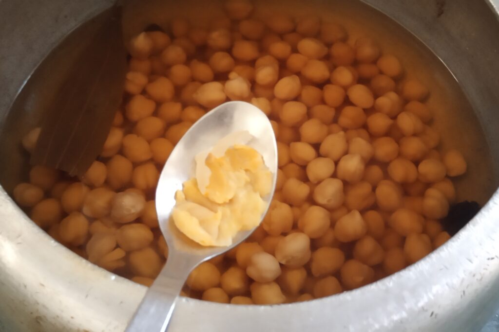 Cooked chickpeas mashed in spoon